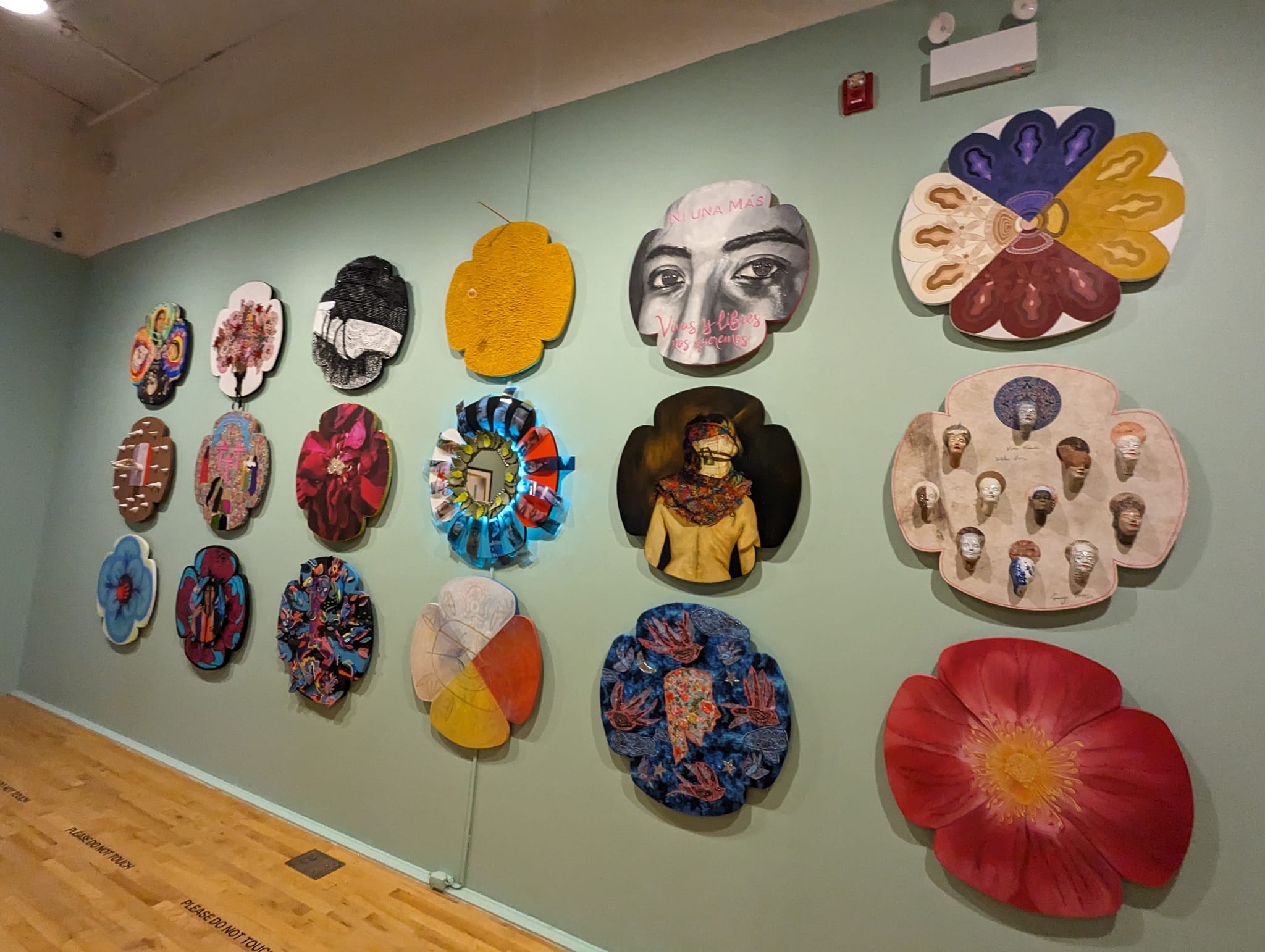 A wall full of flowers with 4 petals all created by different Chicago artists